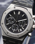 Silver watch with black face on a dark background