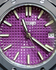 Watch with a purple face and black case on a dark background