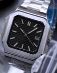 Silver watch with black face on a stand