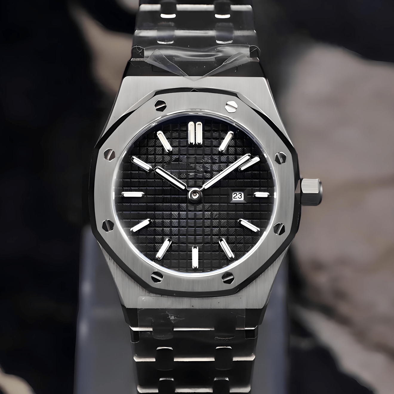 Silver watch with black face on a stand