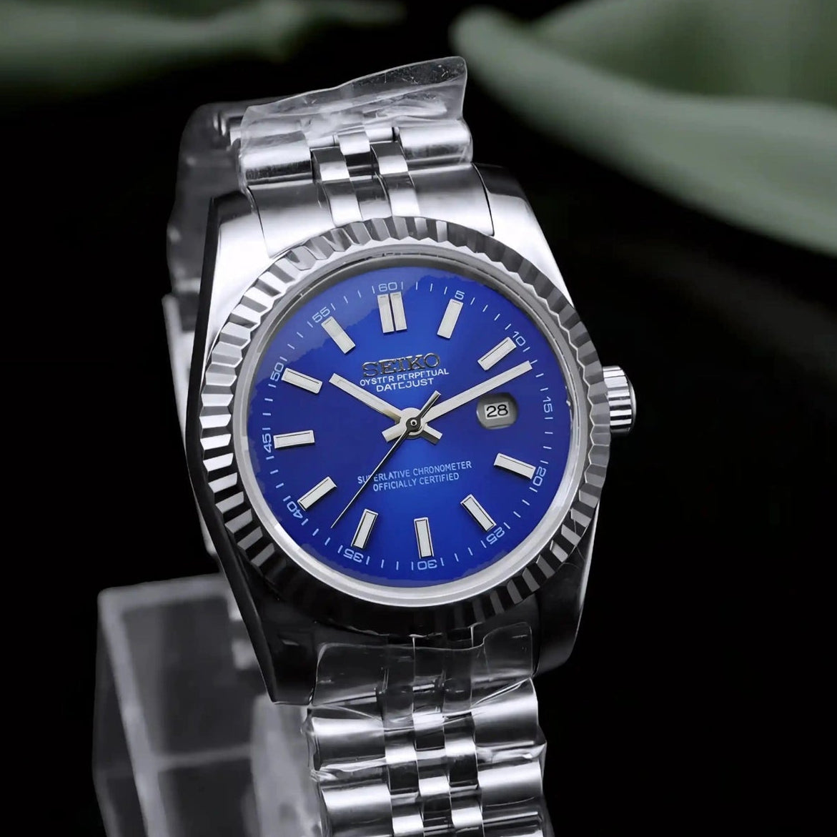 Silver watch with blue face on a black background