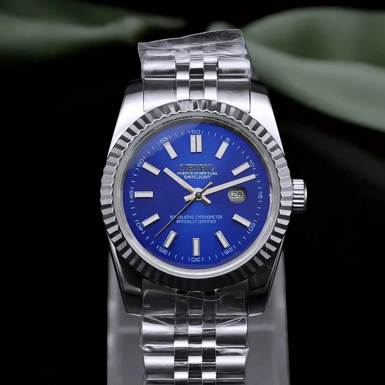 Silver watch with blue face on a black background