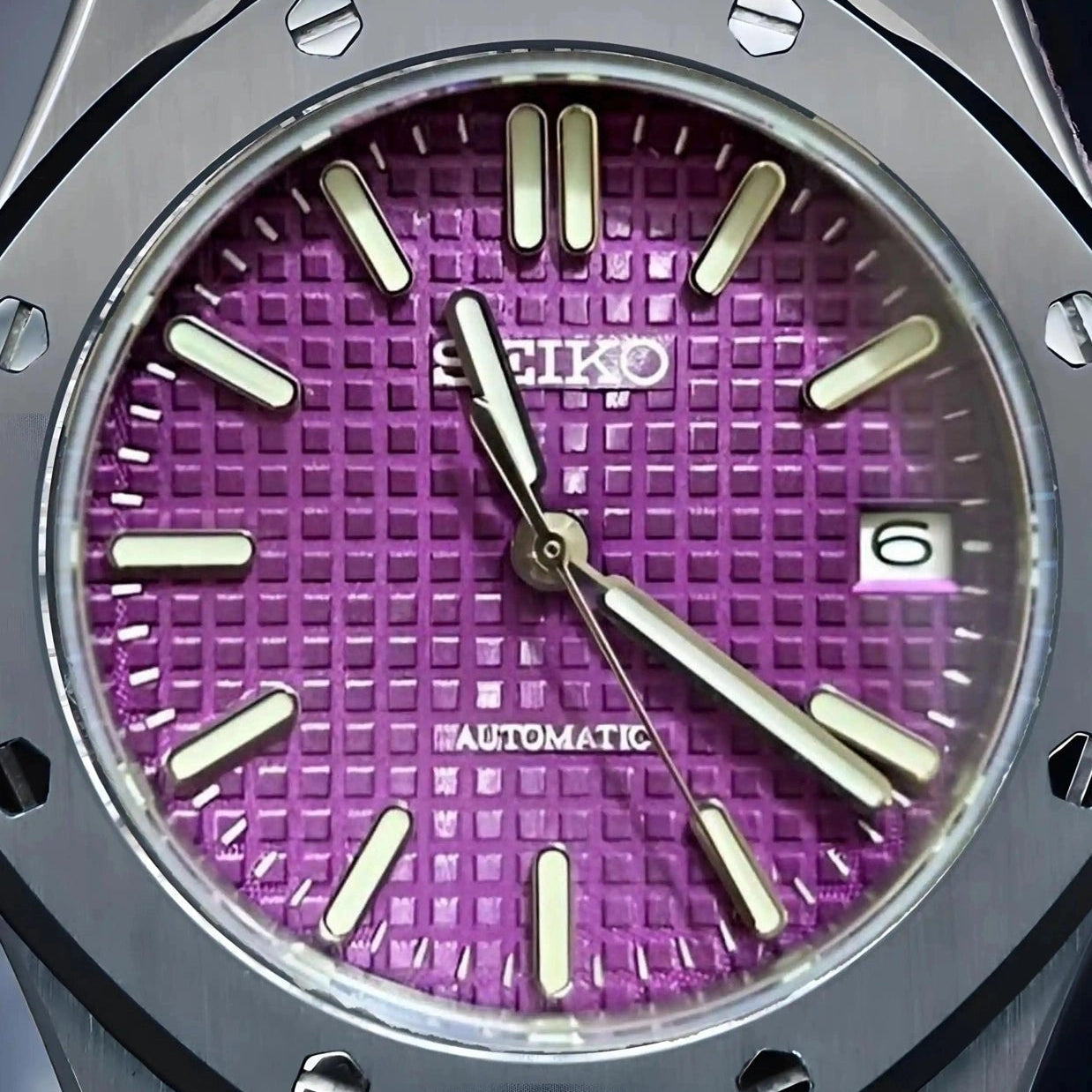 Watch with a purple face and black case on a dark background