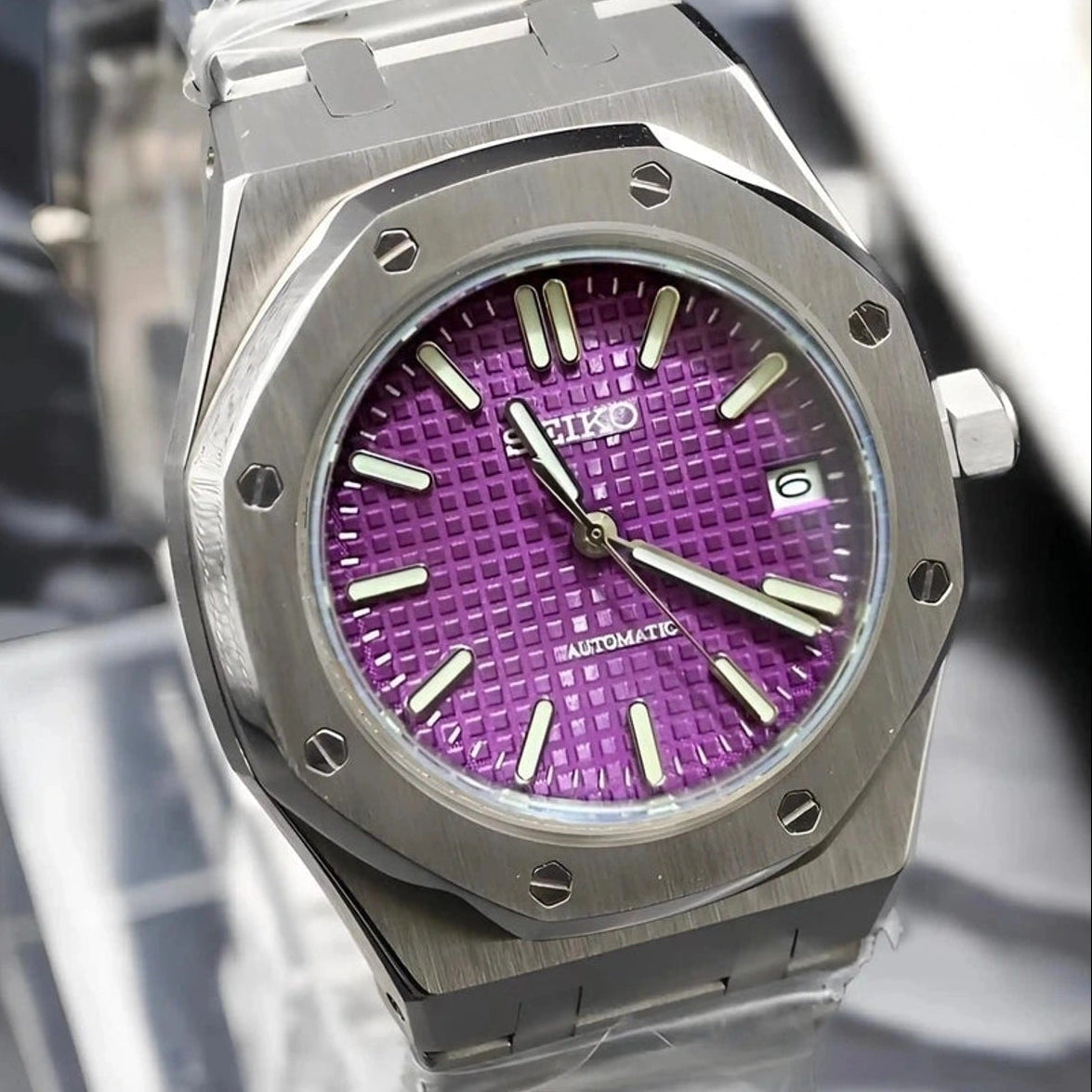 Watch with a purple face and silver case on a blurred background