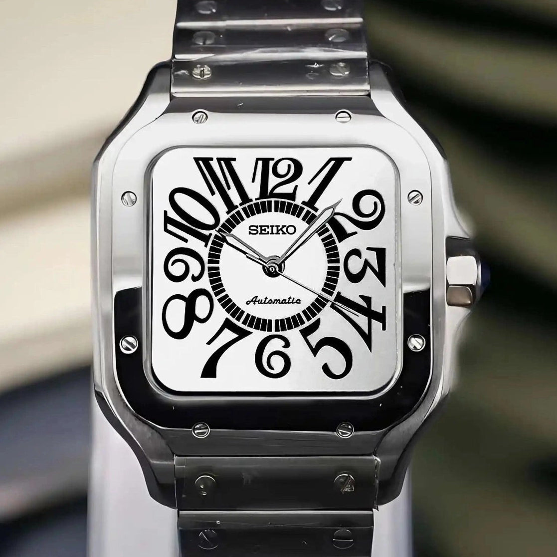 Silver Seiko watch with black face on a marble surface