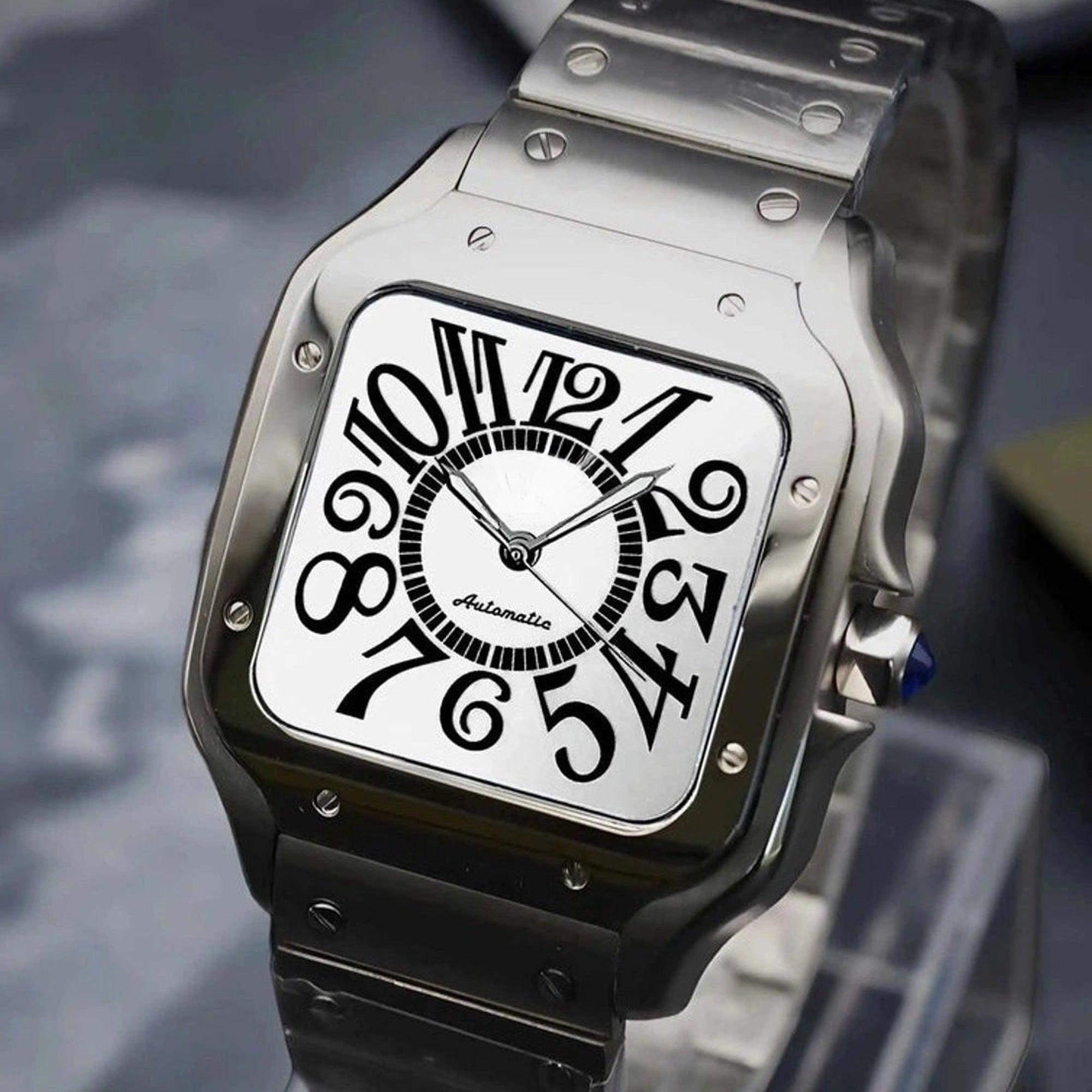 Silver watch with black face on a stand