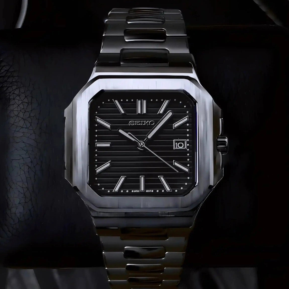 Luxury watch with a black face and silver band on a dark background