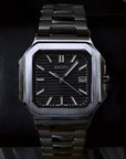 Luxury watch with a black face and silver band on a dark background