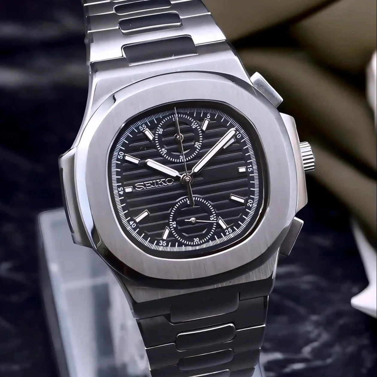 Silver watch on a stand with a blurred background