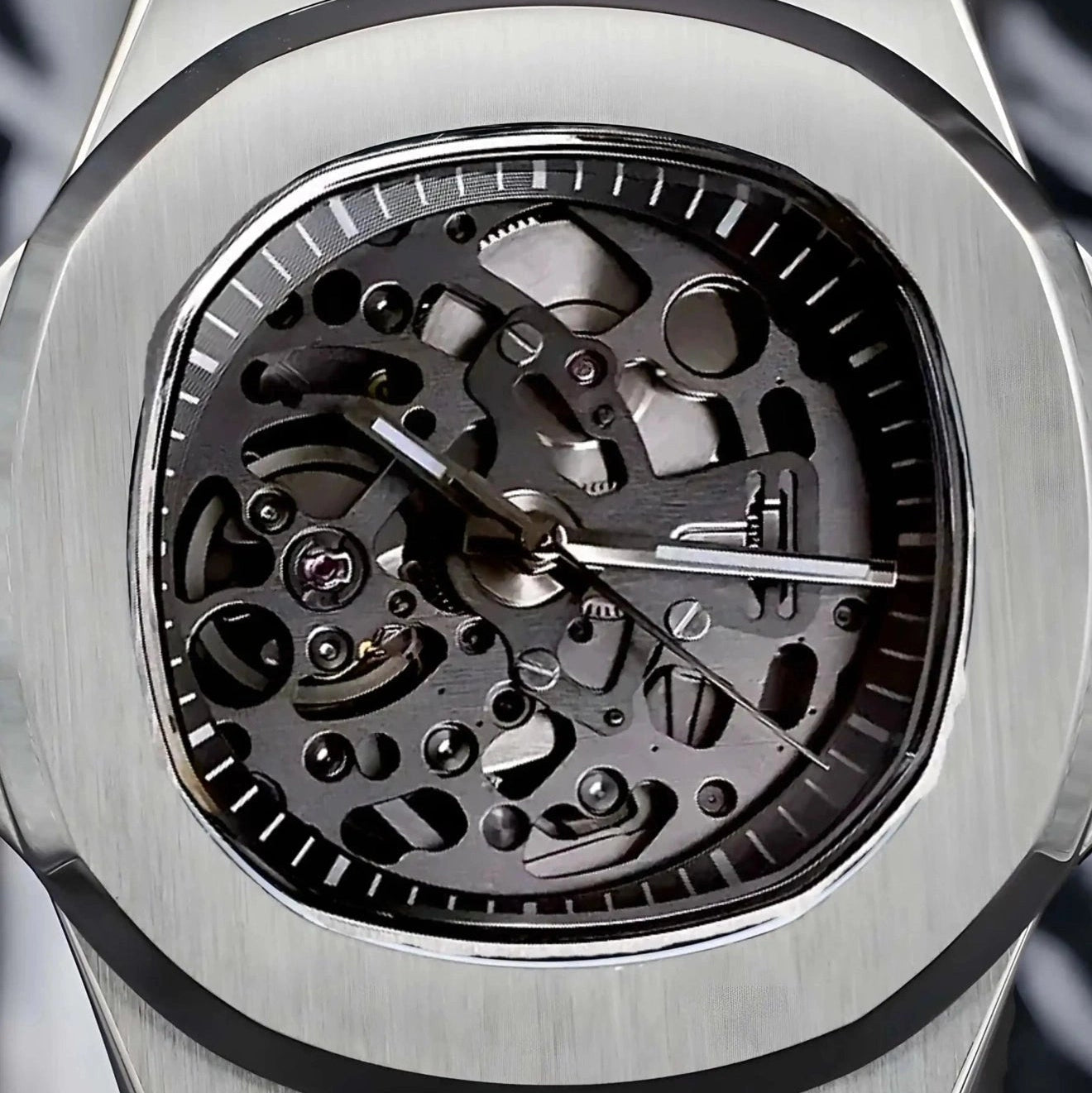 Silver skeleton watch with a detailed mechanical movement on a dark background