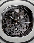 Silver skeleton watch with a detailed mechanical movement on a dark background