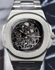 Silver skeleton watch with visible brand logo on a marble surface