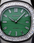 Silver Seiko watch with green face and diamond bezel on a dark background