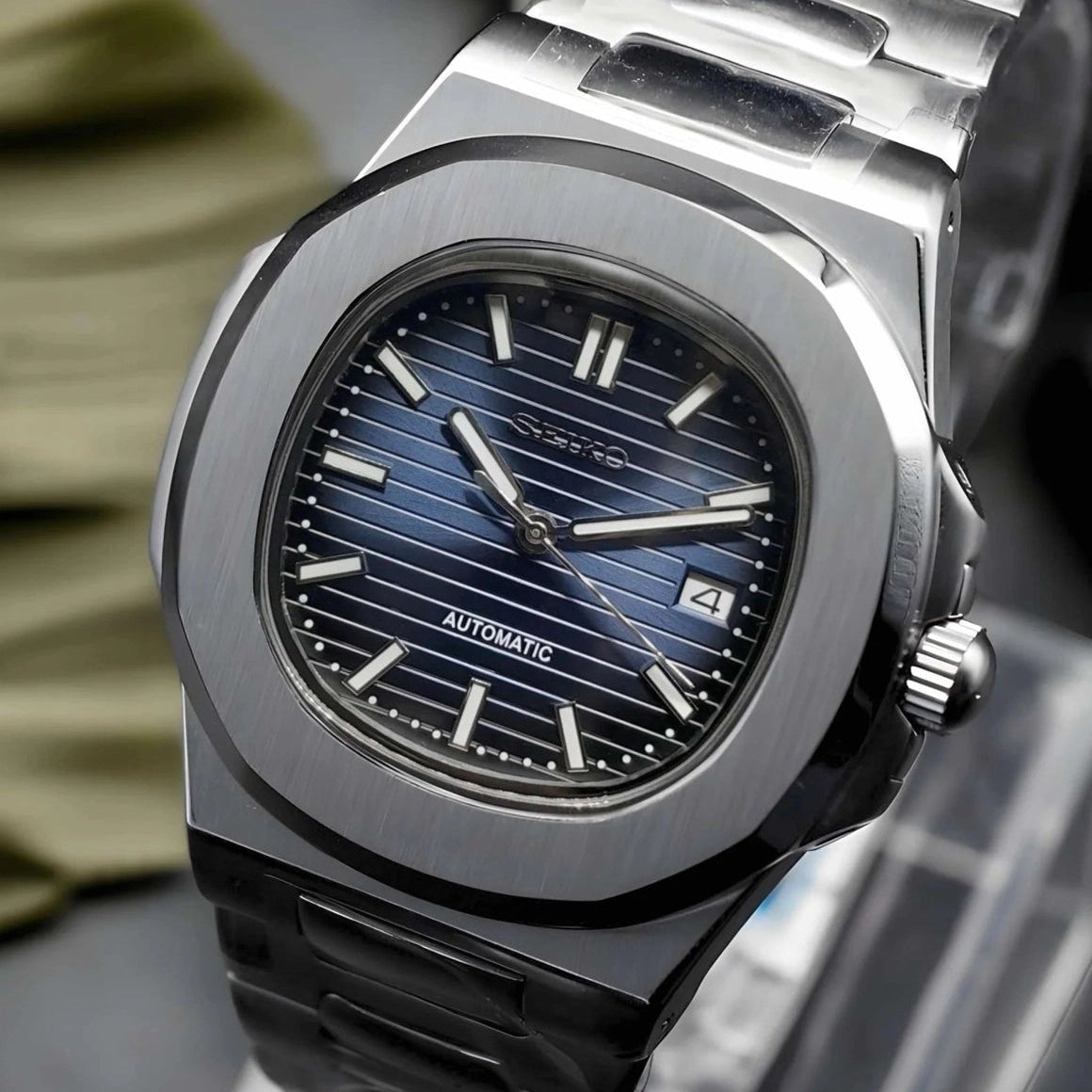 Luxury watch with blue dial and black strap on a stand