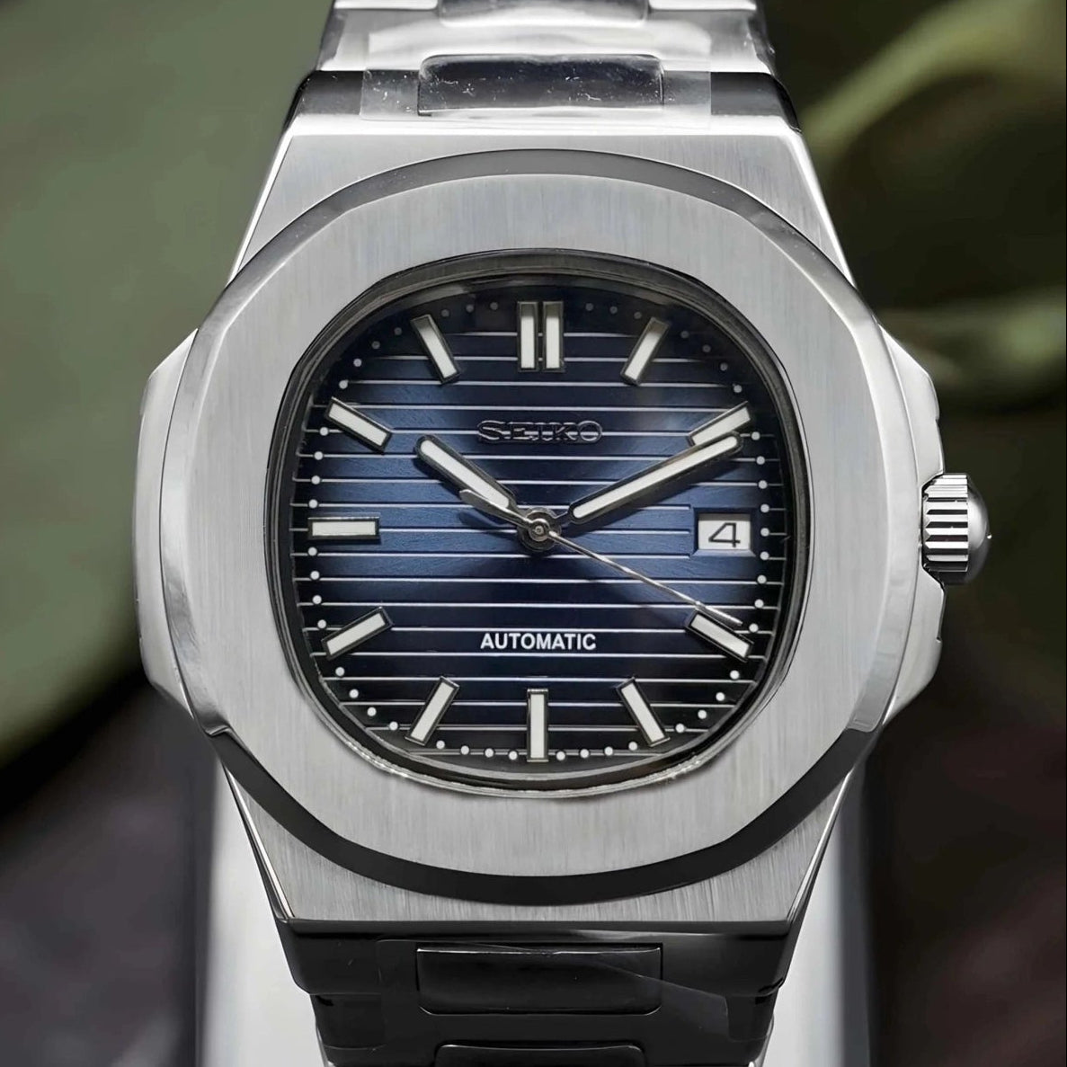 Silver watch with blue face on a stand