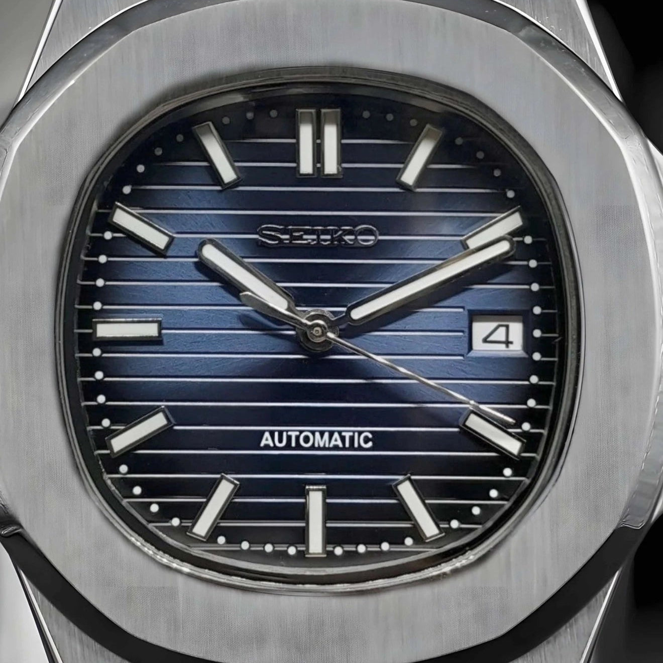 Seiko watch with blue face and silver case on a black background