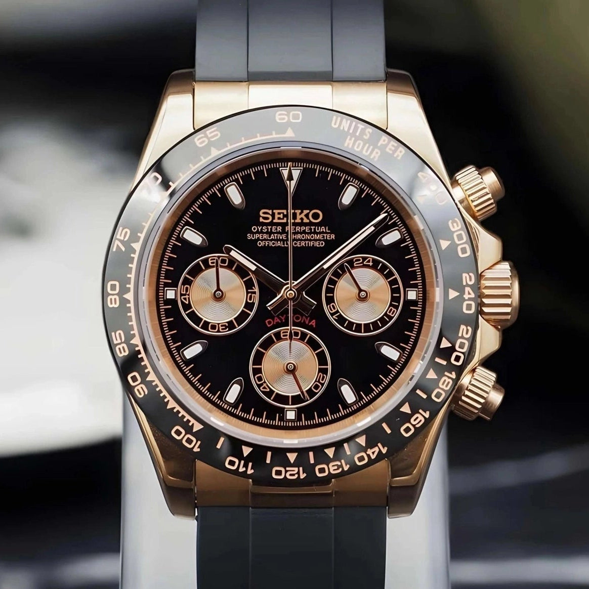 Seiko watch with black and rose gold design on a blurred background